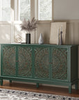 Green carved sideboard styled by a window