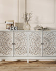 White carved sideboard with four floral-carved doors in a panelled room