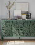 Carved green sideboard with four floral-carved doors, styled with art