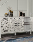 Carved white sideboard in an entryway with one door open