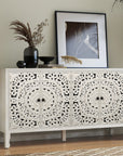 Carved white sideboard with four floral-carved doors, styled with vases and framed art