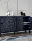Carved navy blue sideboard in an entryway with one door open