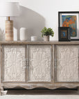 Light gray Irim accent cabinet with three carved floral doors, styled with a lamp and art