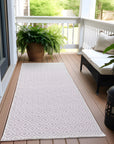 Patterned outdoor rug on a wooden deck with plants and furniture.
