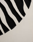 Jardine Marketplace Caribbean Art - A close-up of a black and white pattern featuring bold, wavy black stripes on a white background.